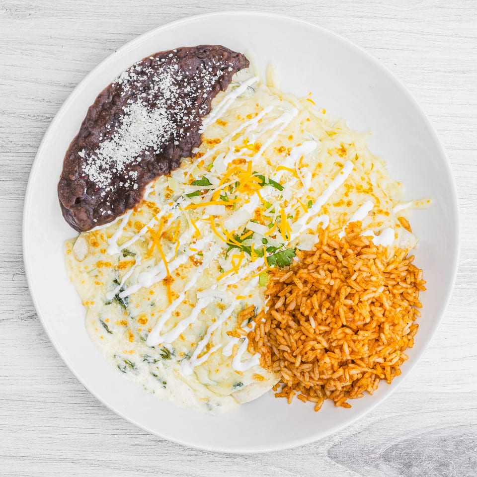 Prados Modern Mexican Cantina's enchiladas with rice and refried beans, topped with cheese and sour cream.