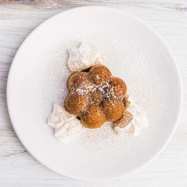 Prados' Mexican dessert, a flower-shaped cake with whipped cream, powdered sugar, and cinnamon.