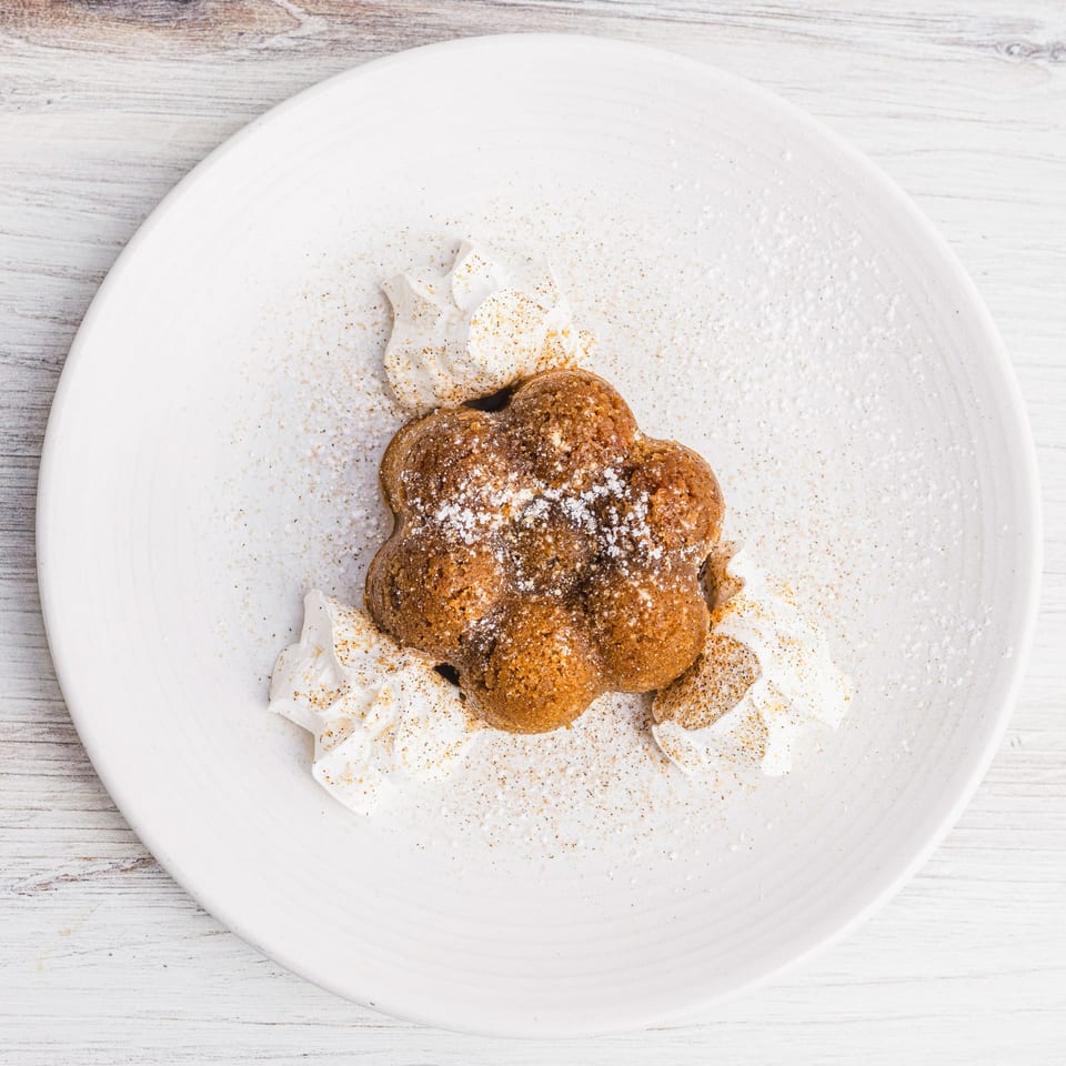 Prados' Mexican dessert, a flower-shaped cake with whipped cream, powdered sugar, and cinnamon.