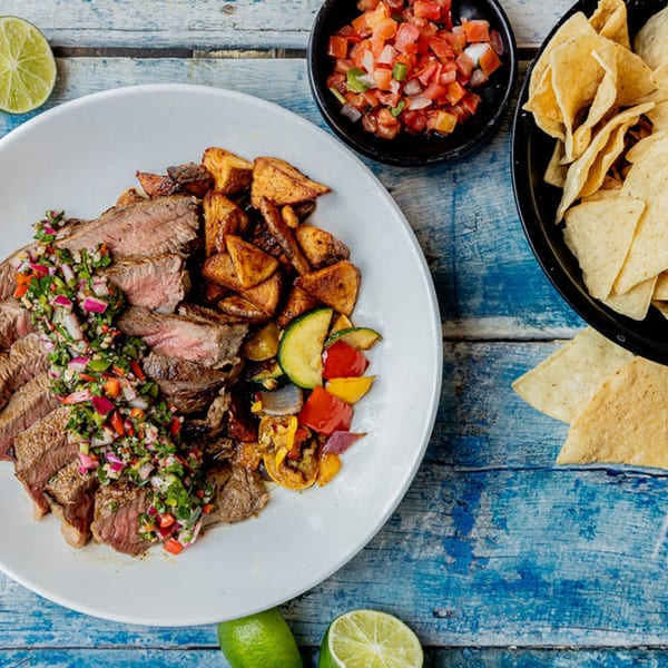 Prados Modern Mexican Cantina's steak with chimichurri, roasted potatoes, vegetables, salsa, and tortilla chips.