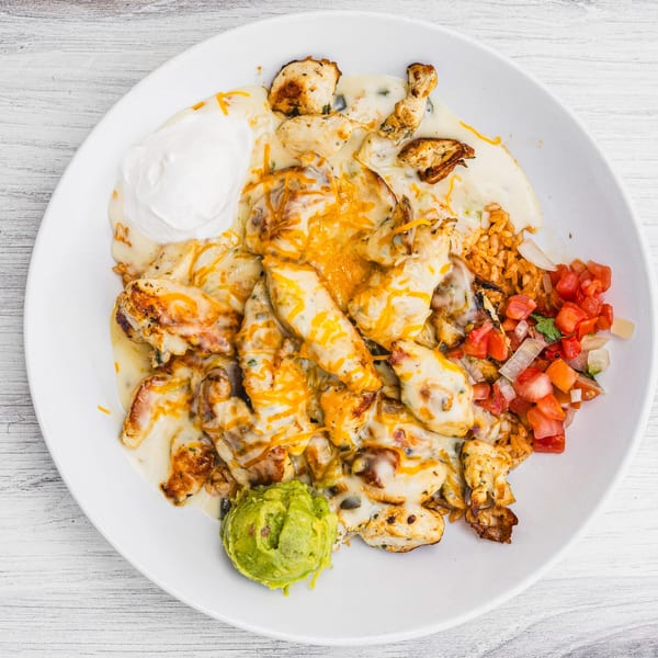Prados Modern Mexican Cantina's cheesy chicken dish with rice, pico de gallo, sour cream, and guacamole.