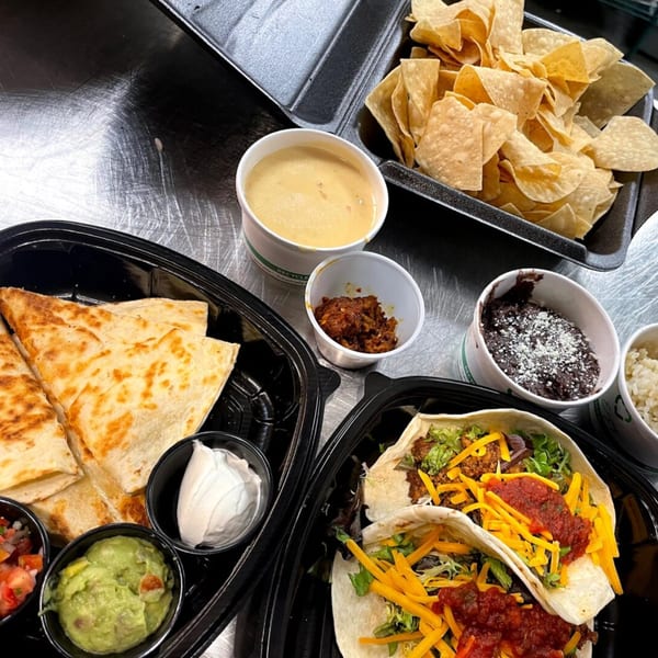 Prados Modern Mexican Cantina takeout meal with quesadillas, tacos, chips, queso, guacamole, and salsa.