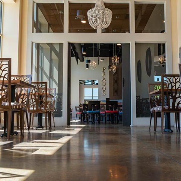 The entrance to Prados Modern Mexican Cantina, featuring a chandelier and stylish seating.