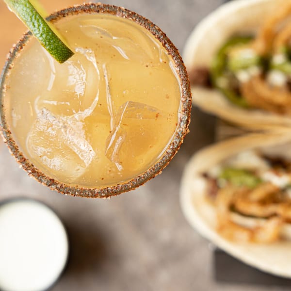 Overhead view of a Prados Modern Mexican Cantina margarita with a lime and tacos.