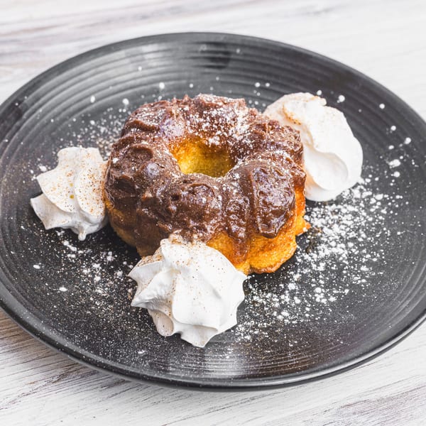 Prados Modern Mexican Cantina's bundt cake with chocolate glaze, powdered sugar, and whipped cream.